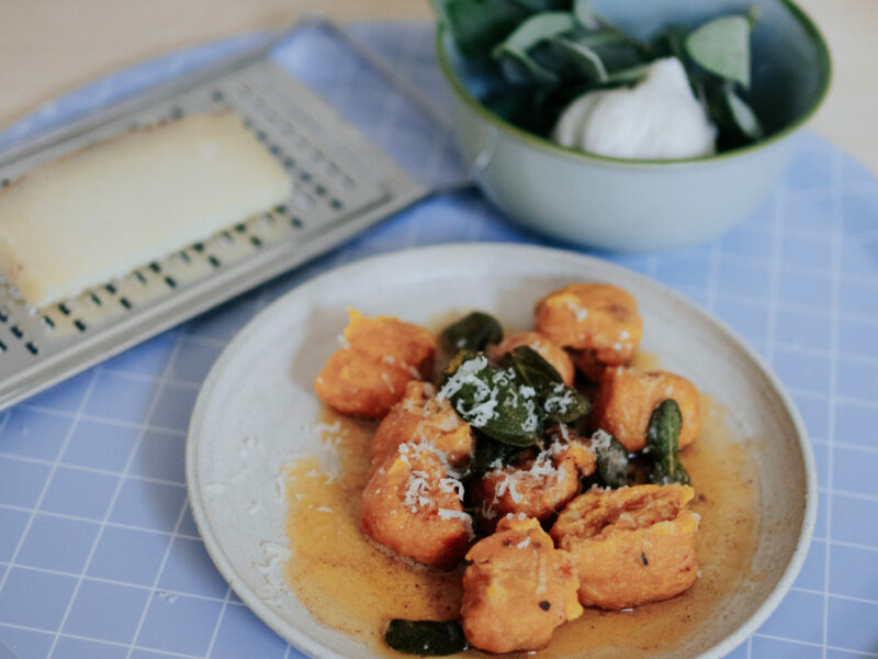 Kürbis Gnocchi mit Salbeibutter und Pecorino auf weißem Teller und hellblauem Tablett von nuukk.