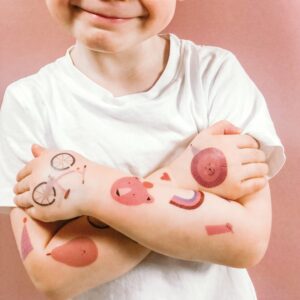 Kinderarme mit temporären Tattoos. Kindertattoos von nuukk. Motive: Bär, Fahrrad, Regenbogen, Löwe, Birne