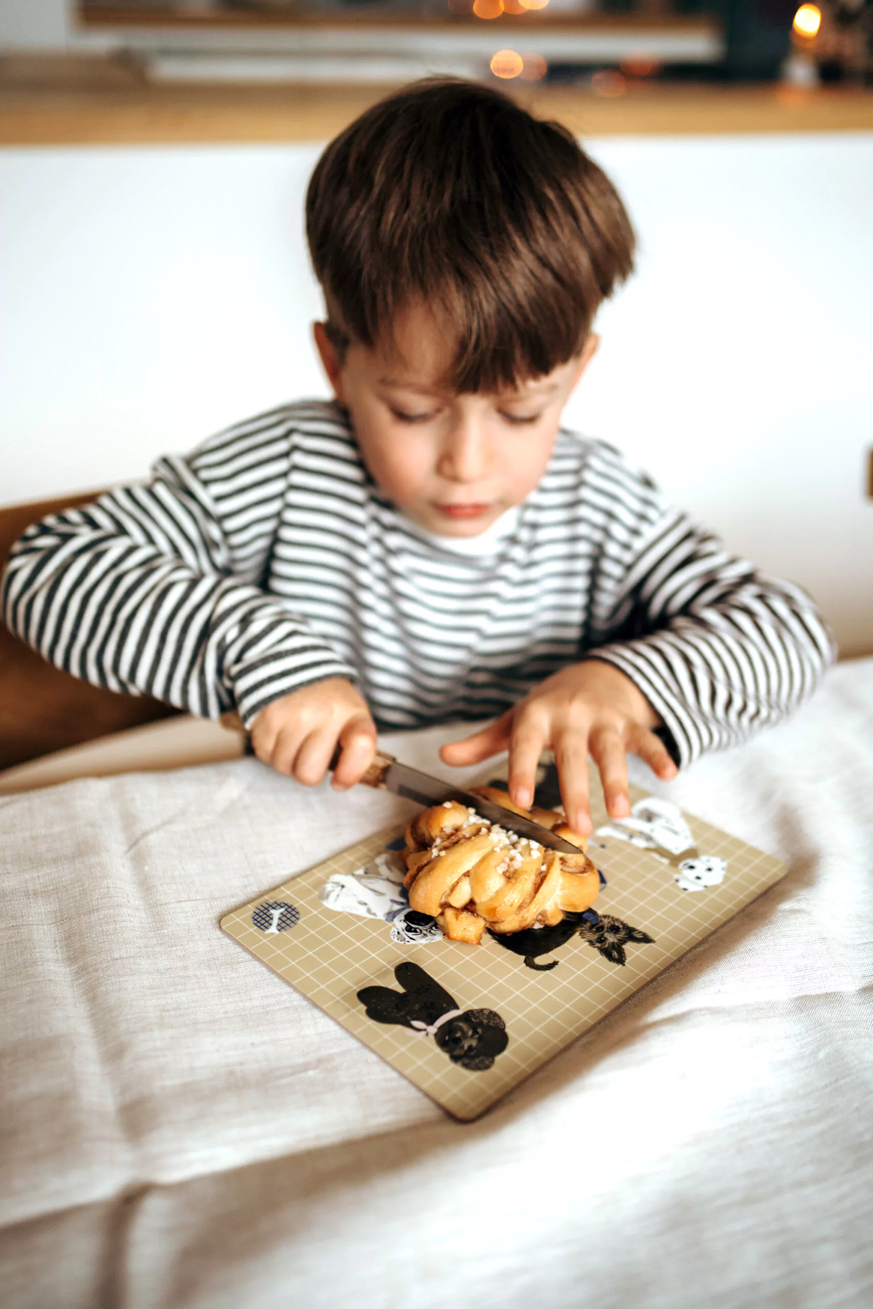 nuukk, Tisch mit Schneidebrett / Frühstücksbrettchen für Kinder, Motiv: Hunde. Kind schneidet Zimtschnecke